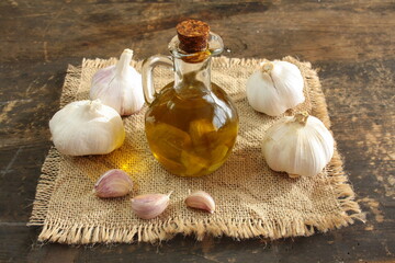 Dzbanek z oliwą aromatyzowaną czosnkiem i główki czosnku © Monika
