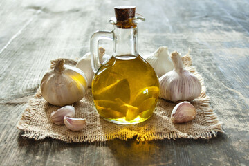 Dzbanek z oliwą aromatyzowaną czosnkiem i główki czosnku © Monika