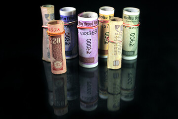 Now and old Indian currencies. 50, 100, 200, 500 rupee notes and coins. Indian currency isolated on black background.