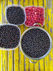 raspberries and black currants on a yellow background