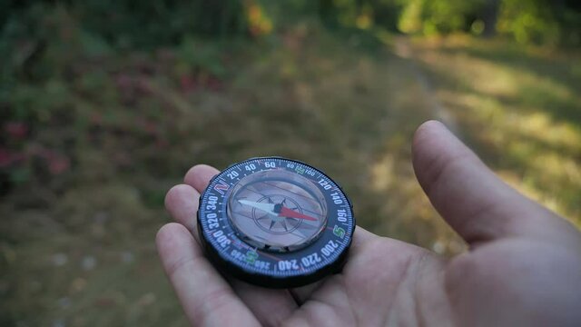 Female forwarder hands holding a compass and looking for direction. Orientation in forest 4k close-up in motion 4k