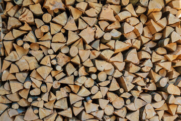 Stack of dry chopped wooden logs. Wooden background for design.