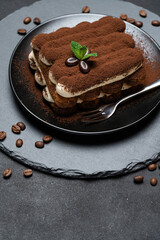 Classic tiramisu dessert on ceramic plate on concrete background
