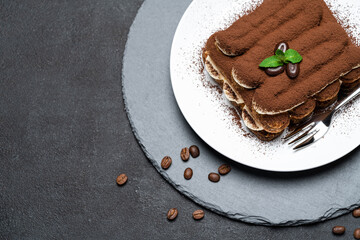 Classic tiramisu dessert on ceramic plate on concrete background