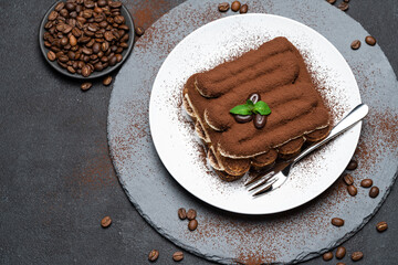 Classic tiramisu dessert on ceramic plate on concrete background