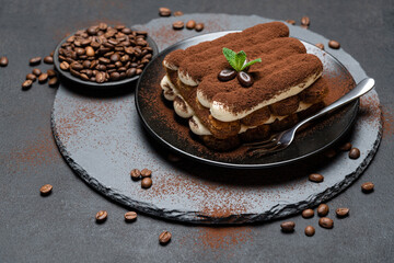 Classic tiramisu dessert on ceramic plate on concrete background