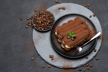 Classic tiramisu dessert on ceramic plate on concrete background