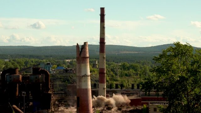 Explosive detonation of the base of the chimney. The collapse of an industrial chimney. Explosion of an old chimney of an obsolete metallurgical plant.