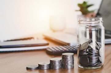 coins in jug glass On the desk. accounting saving money concept financial