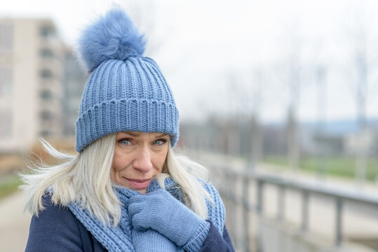 Attractive Blond Woman Snuggling Into A Warm Scarf