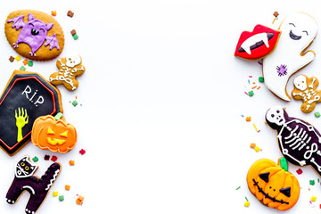 Frame of Halloween decorations with cookies and candies, top view