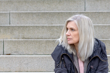 Casual middle-aged woman sitting on outdoor steps