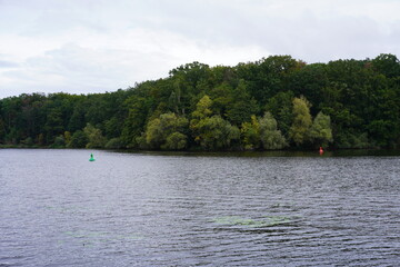 Fototapeta premium Seenlandschaft mit Bojen und Wald