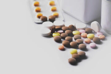 Medicines and bottle on white surface of table.