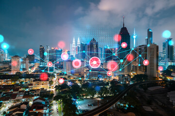 Abstract technology icons, night aerial panoramic cityscape of Kuala Lumpur, Malaysia, Asia. The concept of innovative approach to optimize international business process. Double exposure.