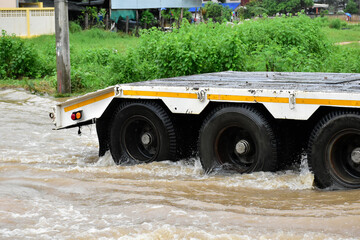 The pickup truck is passing the urban road which fulled of floodwater in the heavy raining day. © Sophon_Nawit