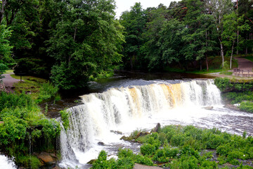 Wonderful view of the waterfall with green trees. Keila-Joa hydroelectric power station, Estonia.