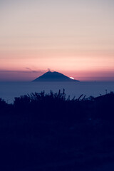 Amazing view of the Stromboli Volcano at sunset, wit the sun going down and amazing sea and sky...