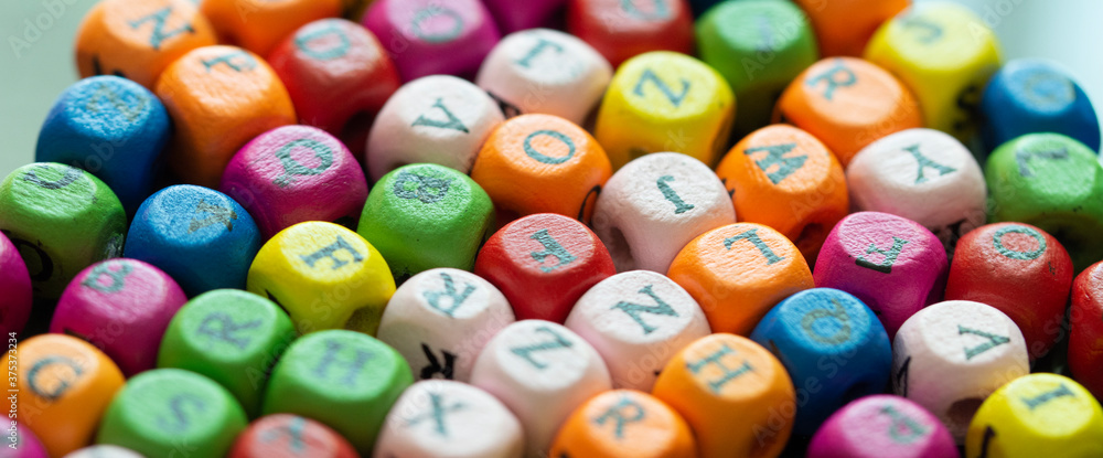 Fototapete colored cubes with letters. multi-colored alphabet macro photography. wooden elements of the game