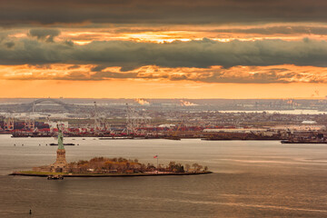 New York Harbor, New York, USA with the statue of liberty and Bayonne, New Jersey in the background.