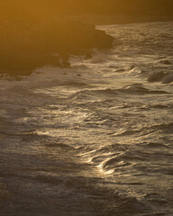 waves on a beach druing sunset dark yellow mood
