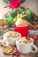 Christmas fruitcake in mug. Simple and fast recipe idea for Christmas breakfast, mugcake in microwave with traditional winter spices and fruits, on xmas decorated wooden background copy space
