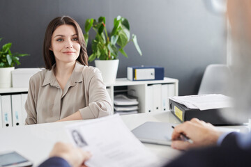 Confident Caucasian woman sitting in front of professional HR manager at office desk having job interview