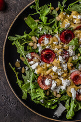 Salad with arugula, cherries, goat cheese, pine nuts, mustard -olive oil dressing