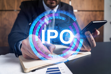 A man in office taking notes using phone and ipo theme hologram. Multiexposure. Formal wear. Invest...