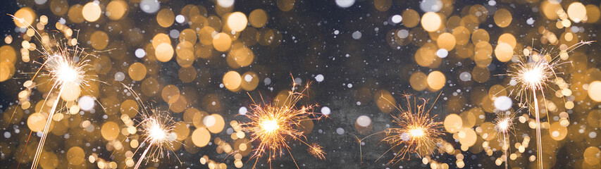 Silvester / new year background banner panorama long- Golden firework sparklers  in the dark black...