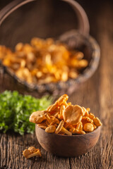 Raw chanterelles mushroom in wooden bowl with parsley herbs