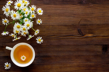 Herbal tea with chamomile flowers, top view copy space