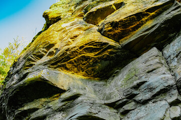 Three-dimensional stone rocks of different shapes in the rays of the setting sunlight. Old rocky formations with stripes of white and red paint