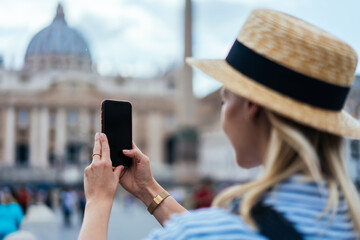 Fototapeta premium Happy woman taking shot of cathedral in Rome