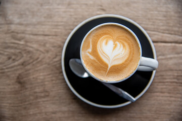 cup of hot latte on wooden table