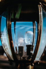 Two lights bulbs that are different sizes with the smaller one shining brighter 