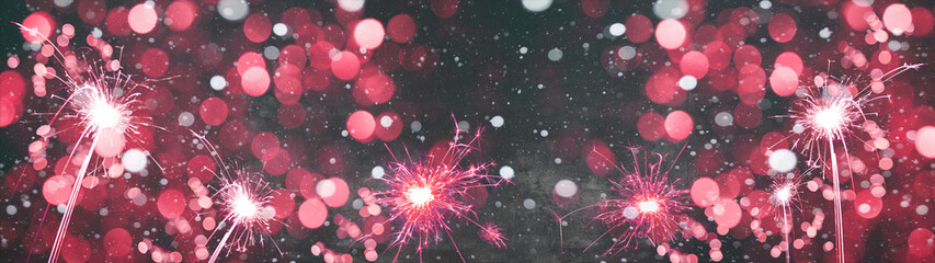 Silvester / new year background banner panorama long- Pink firework sparklers in the dark black...