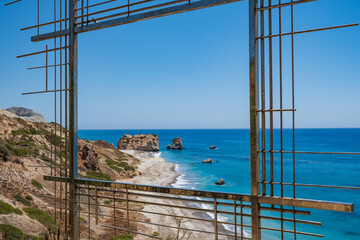 Petra tou Romiou, Aphrodite's birthplace in Paphos, Cyprus behind a framed construction