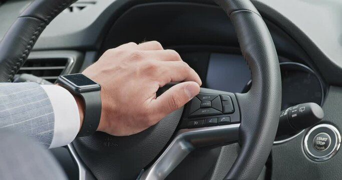 Nervous driver pushing horn on leather steering wheel in car