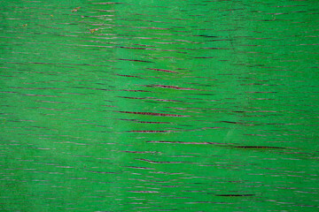 Texture of weathered green wood panel. There are some cracks in the surface