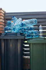 Disposal containers with empty used plastic water bottles on the top. Collecting plastic waste to...