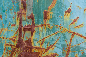 Old metal surface for the backdrop. Peeling paint. Color - blue, green, orange. Rust, crumpled, creases, flakes.
