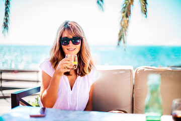 Happy woman enjoying sunny day while relaxing outdoor sofa