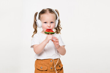 Portrait of young child girl in headset eat candy on white background