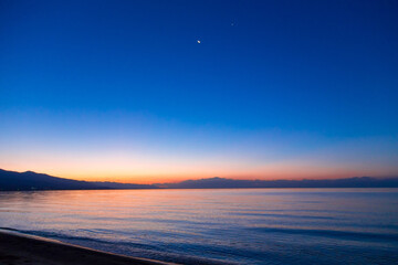 Fototapeta premium Dawn of the sun at sea. The rising sun behind the mountains. Kyrgyzstan.