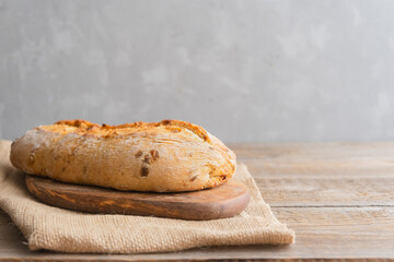 Freshly baked ciabatta lies on a wooden board. Home baked goods, bakery. Place for text