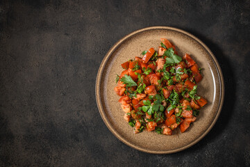 Fresh tomato salad with parsley, coriander, dill, spring onion and ground cumin. Moroccan tomato salad. Top view. Copy space