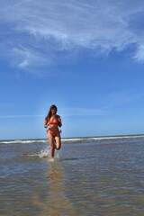 Fototapeta premium Magnifique jeune femme qui court sur la plage