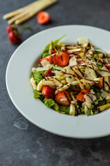 Healthy salad with strawberry, white asparagus, arugula, parmesan cheese.