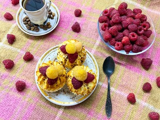 Freshly baked curd muffins with raspberries and a cup of aromatic invigorating coffee.The concept of homemade baking, proper nutrition, agriculture.